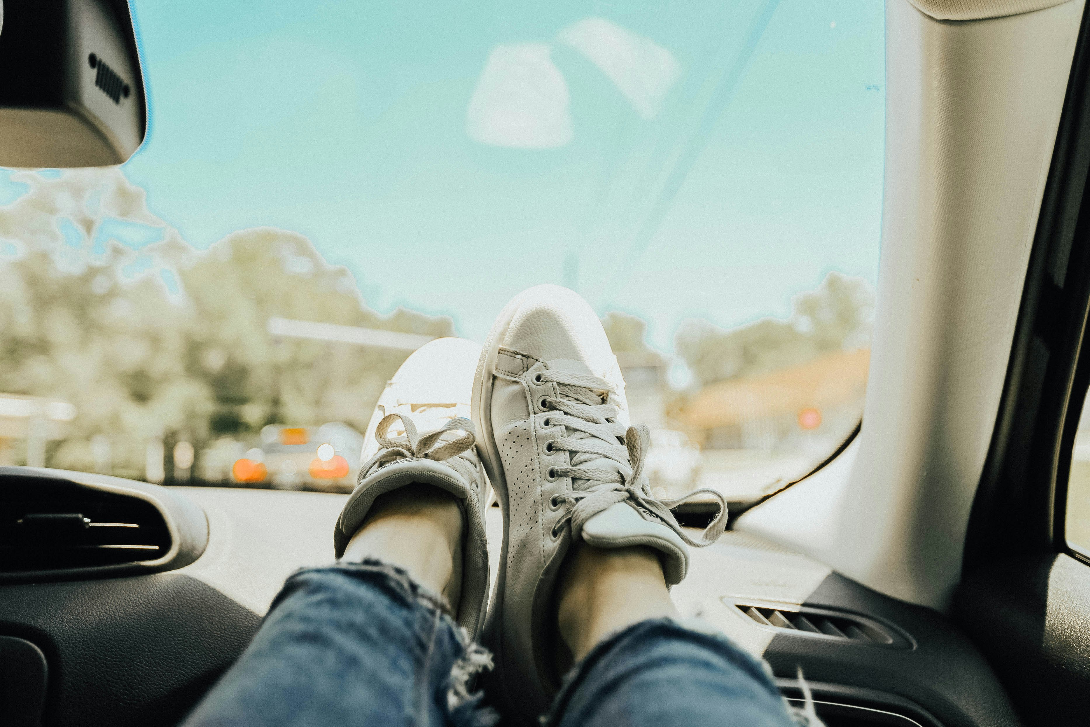 person resting feet on car dashboard